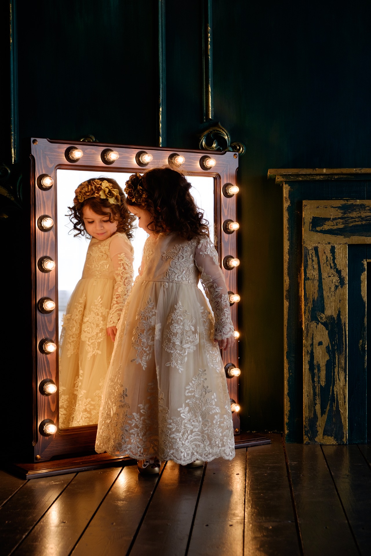 Une petite fille se regarde dans un miroir