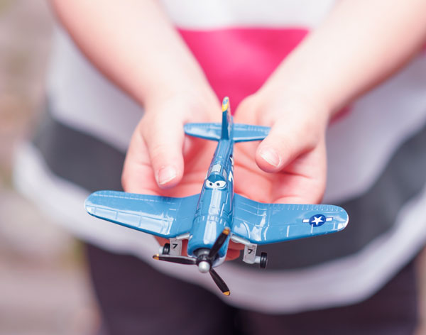 Tarification pour les séances de sophrologie Enfant avec un avion entre les mains